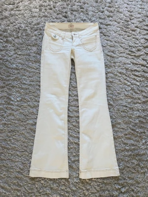 Vita bootcut jeans från Nelly - Säljer ett par superfina vita bootcut jeans från Nelly med snygga detaljer som framfickor.  Perfekta för dig som gillar stilrena och trendiga jeans. De är använda en gång, några små fläckar finns (se bild), går nog att få bort. Säljer då de tyvärr inte passar. 