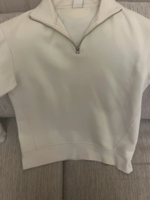 Vit halvzip hoodie från Zara - Säljer en vit hoodie från Zara med halvzip och hög krage. Använd några gånger men ser helt ny ut.