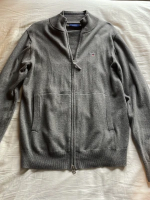 Gant zip tröja - En grå fullzip gant tröja i riktigt skönt tyg. Den är använd ett par gånger men är i nytt skick. Den köptes på deras hemsida för något år sedan för cirka 1500kr