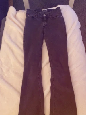 Mörkgråa/svarta bootcut jeans - Säljer ett par mörkgråa/svarta bootcut jeans. Jeansen har utsvängda ben och normal midja, Materialet är mjukt denim som ger en bekväm passform.