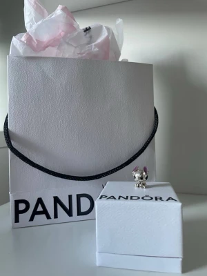 Pandora berlock Stitch silver - Söt berlock från Pandora i form av Disney-karaktären Stitch. Tillverkad i silver med detaljer i lila på öronen. Perfekt att hänga på armband eller halsband för en personlig touch.