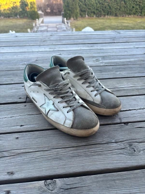 Golden Goose  - Tja. Säljer ett par feta golden goose i storlek 43, 100% äkta. Skorna är väldigt unika och i bra skick men slitits lite vid hälen som ej syns när man har på sig skorna. Ett par skor som ger dig många komplimanger och väldigt unika så kom privat vid minsta lilla och pris går givetvis att diskutera🍾🍾🥂