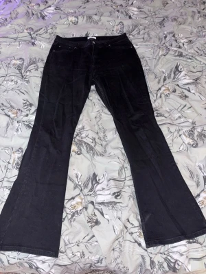 Svarta bootcut jeans - Säljer ett par svarta bootcut jeans med klassisk femficksdesign. Jeansen har utsvängda ben och är tillverkade i ett stretchigt denimtyg som sitter snyggt. Perfekta för dig som gillar en retroinspirerad look. (OBS! Jag tog bilderna innan de tvättades, så de skickats såklart inga smutsiga kläder)