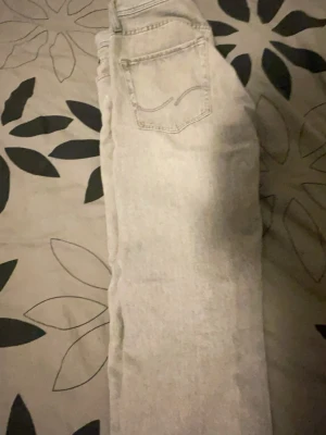 Ljusgrå relaxed jeans Jack & Jones - Säljer ett par ljusgrå relaxed fit jeans från Jack & Jones, modell Chris. Klassisk femficksdesign och raka ben. Perfekta för en chill och avslappnad stil. Tillverkade i mjukt denimtyg som är skönt att bära hela dagen.