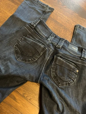Mörkblå jeans från pepe jeans  - Säljer ett par mörkblå jeans från pepe jeans med klassisk femficksdesign och raka ben. Jeansen har kontrastsömmar och tydliga bakfickor Materialet är slitstark denim i bomull. Perfekta för en avslappnad och tidlös stil.