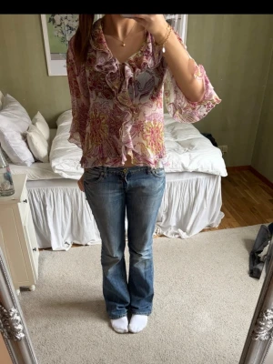 Blommig volangblus med trekvartsärm - Säljer en jättefin luftig Zara blus med volangkant och blommigt mönster i rosa, lila och gult. Blusen har trekvartsärmar och är tunn i materialet, perfekt till sommaren! 