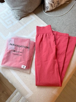 Flare leggings NVGTN - Snygga röda sömlösa leggings från NVGTN i modellen Cherry Crush Iconic Seamless. De har hög midja och utsvängda ben, vilket ger en trendig flare-look. Perfekta för gymmet eller chill. Materialet är stretchigt och följsamt för bästa komfort. Råkade beställa 2 därav jag säljer ens, helt oanvända.