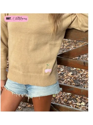 Beige stickad tröja med körsbär - Snygg beige stickad tröja från MMT x Filippa med ett litet broderat körsbär i rosa och grönt nedtill. Tröjan har rund hals, långa ärmar och breda ribbade muddar vid ärmslut och nederkant. Perfekt för en chill och trendig look.