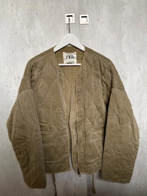 Jacka, Zara - Grön quiltad jacka från Zara med rundad halsringning och dragkedja framtill. Jackan har två fickor och en loose passform. Materialet är mjukt och ger en avslappnad vibe, perfekt för lager på lager. Storlek 38/M💞