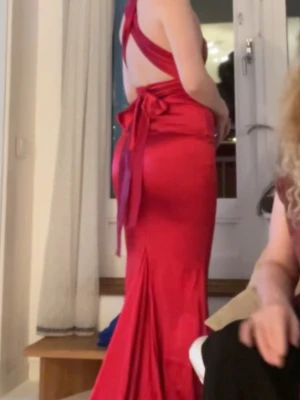 Röd långklänning med öppen rygg - Jätte fin balklänning eller bra klänning för fest. Banden går att knyta hur man vill! Så fin men tyvärr inte helt min stil. Den är helt oanvänd med lappen kvar! Pris går att diskutera men endast vid snabb affär. 