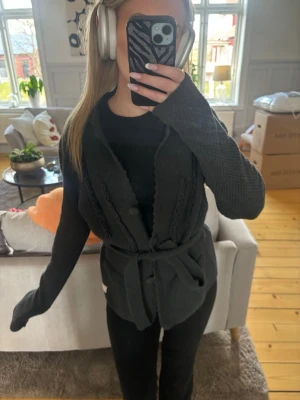 Mörkgrå stickad kofta från odd molly - Mysig mörkgrå stickad kofta med bälte i midjan och detaljer längs kanterna. Koftan har långa ärmar, knappar framtill och två fickor. Storlek 3 från odd Molly, jag brukar ha xs/s. Kolla gärna mina andra annonser för paketpris!🤍
