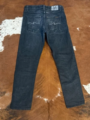 Nudie GrittyJackson black selvage - Tjena! Säljer dessa riktigt snygga limited edition nudies, byxorna är i fint skick och är i storleken W29/L30, bild 3 är exakt samma modell men inte samma par, hör av dig vid funderingar!🙌