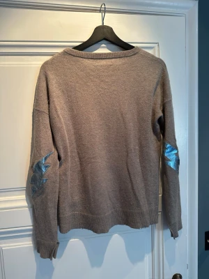 Zadig & Voltaire cashmere sweater beige S - Elegant beige cashmere tröja från Zadig & Voltaire med deras statement patch på armbågarna. Nypris 3 900kr.  Klassisk och tidlös modell som passar till allt, perfekt basplagg i garderoben.   Väldigt mjuk och skön kvalitet och sitter fint både instoppad i jeans eller över kjol.  Storlek S men passar även M beroende på passform. Super skick (använt max 5 gånger).