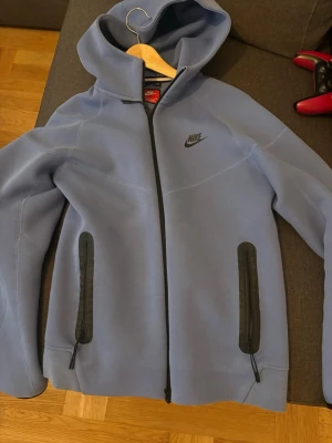 Blå Nike hoodie med dragkedja - Snygg blå hoodie från Nike med hel dragkedja framtill och två svarta dragkedjeförsedda fickor. Hoodien har en klassisk huva och Nike-logga på bröstet. Tillverkad i mjukt material som passar perfekt för en avslappnad stil.                              helt ny Använd max 3 gånger pris går att diskutera vid snabb affär 