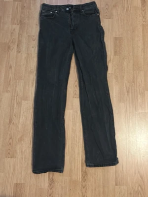 Svarta raka jeans från Weekday - Säljer ett par svarta jeans från Weekday med rak passform och klassisk femficksdesign. Jeansen har normal midja och är tillverkade i ett mjukt denimtyg som sitter snyggt. Perfekta för dig som gillar en clean och enkel stil.