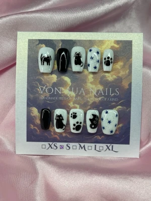 Meow (S);Short Ballerina - Handgjorda press-on naglar i svart och vitt med söta kattmotiv, tassavtryck och blå stjärnor. Mixade designer på varje nagel för en unik look. Perfekt för dig som älskar djur och vill ha något personligt och kreativt på naglarna.S: 15 mm, 11,5 mm, 12 mm, 11 mm, 9 mm 