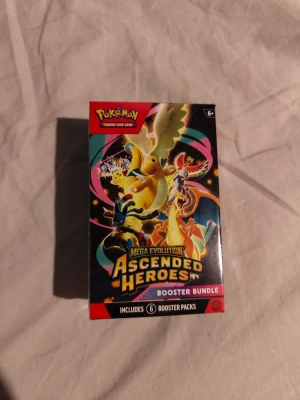 Pokémon Ascended Heroes Booster Bundle - Mega Evolution Ascended Heroes Booster Bundle till Pokémon Trading Card Game. Boxen är färgglad med motiv av olika Pokémon och innehåller 6 booster packs. Perfekt för dig som vill utöka din samling eller spela med vänner. Officiell produkt med cool design.