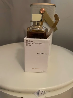 Maison Francis Kurkdjian Grand Soir EdP - Maison Francis Kurkdjian Grand Soir Eau de Parfum i elegant glasflaska med guldigt lock. Flaskan rymmer 70 ml och kommer i en stilren vit kartong. Doften är lyxig och exklusiv, perfekt för dig som gillar unika parfymer.
