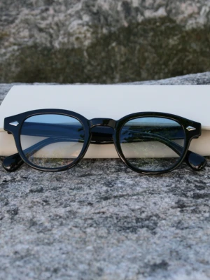 Civare Blue Fade shades - Snygga svarta solglasögon med klassisk rundad båge och coola detaljer i silver vid hörnen. Glasen är lätt tonade och ramen är i blank plast som ger en stilren och tidlös look. Perfekta för att lyfta vilken outfit som helst.