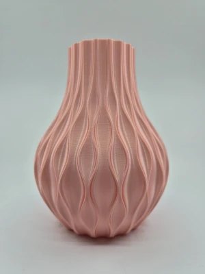 Rosa 3D-printad vas med vågmönster - Säljer en unik vas i ljusrosa plast med ett coolt vågigt mönster. Vasen är 3D-printad och har en modern, rundad form som smalnar av upptill. Perfekt som dekoration eller för LEGO eller evighersblommor. Passar dig som gillar stilren och kreativ inredning.