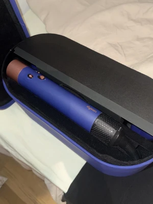 Dyson Airwrap blå hårstyler ny - Säljer en Dyson Airwrap i limited edition blå/lila med kopparfärgade detaljer. Kommer med flera stylingtillbehör som borstar och locktillbehör, allt i ett matchande hårt fodral. Perfekt för att skapa olika frisyrer med skonsam styling. Grym design och riktigt snygg färg! Ny