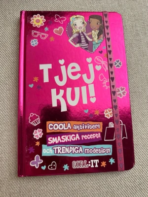 Tjejkul! av GIRL:IT - En glansig rosa bok med hårda pärmar fylld med coola aktiviteter, smaskiga recept och trendiga modetips. Perfekt för dig som vill ha inspiration till pyjamasparty, quiz och roliga saker att göra med din BFF. Boken är dekorerad med färgglada illustrationer och hjärtan.
