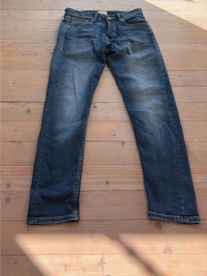 Jeans från Jack and Jones blåa med tvätt och tapered fit - Byxor från Jack and Jones blåa. Storlek 30/32 med tapered - Erik modell