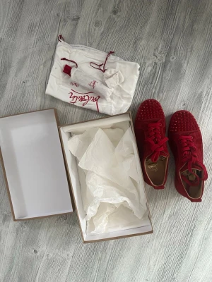 Röda sneakers från Christian Louboutin - Röda loubs i strl 42,5 skick 9/10
