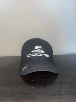 Cobra Keps - En svart keps från Cobra, riktigt fint skick på den då den använts 2-3 gånger bara. Nypris 299kr. Pris går att diskuteras vid intresse.