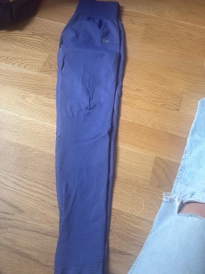 Blå seamless leggings från ICANIWILL - Snygga blå seamless leggings från ICANIWILL med hög midja och ribbad linning. Materialet är stretchigt och följsamt, perfekt för träning eller chill. Diskret logga på höften. Supersköna och sitter på plats hela dagen.