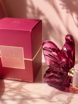 La Bomba parfym från Carolina Herrera - La Bomba Eau de Parfum från Carolina Herrera i en unik, mörkrosa glasflaska formad som en fjäril. Flaskan har gulddetaljer och kommer i en matchande mörkrosa kartong med guldtext. Perfekt för dig som gillar snygg design och exklusiva dofter.