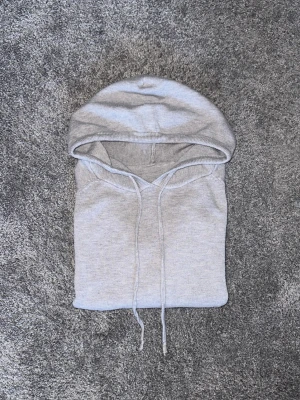 Ljusgrå kashmir hoodie - En stilren ljusgrå hoodie med klassisk huva och dragsko. Hoodien har en enkel design utan synliga loggor eller tryck, vilket gör den lätt att matcha med olika outfits. Tillverkad i mjukt material som känns skönt mot huden.