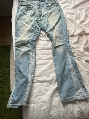 Ljusblå bootcut jeans från boohooMAN - Säljer ett par ljusblå bootcut jeans från boohooMAN i storlek 34. Jeansen har utsvängda ben och klassisk femficksdesign. Tillverkade i denim med ljusa tvättade partier för en cool vintagekänsla.