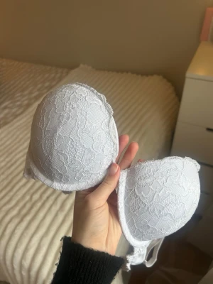 Vit push-upp BH - Säljer en superfin vit push-upp BH från Lindex i storlek 75B, den är använd ett antal gånger men finns inga tecken på fläckar eller andra skador, (såklart en ordentlig tvätt) säljer pga inte min storlek! BH:n har även ganska mycket push-upp och har ändringsbara band💗Nypris: ca 300kr