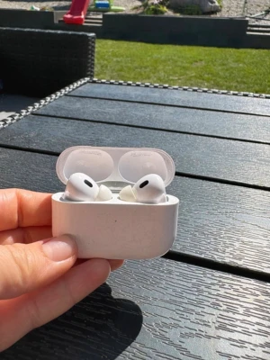 Apple AirPods Pro trådlösa hörlurar - Säljer ett par vita Apple AirPods Pro med laddningsetui. De är trådlösa in-ear-hörlurar med silikonproppar och stilren design. Perfekta för musik, poddar och samtal med grym ljudkvalitet och brusreducering.