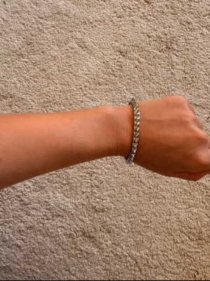Armband från Edblad - Stilrent armband i silverfärg med kedjedesign. Armbandet har en platt och bred form som ger en modern och cool känsla. Perfekt accessoar för att lyfta din outfit med en enkel men trendig detalj.