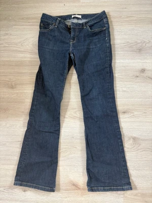 Mörkblå bootcut jeans - Snygga mörkblå bootcut jeans med klassisk femficksdesign och kontrastsömmar. Jeansen har normal midja och lätt utsvängda ben. Perfekta till en avslappnad stil och passar till det mesta. Materialet är klassisk denim i bomull.