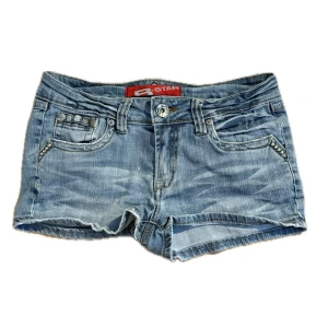 Blå jeansshorts med nitar från B Star - Snygga blå jeansshorts från B Star med coola nitar på fickorna och slitna detaljer. Ingen storlek på lappen men skulle säga S, 37cm tvärs över. Skriv om du har frågor, kolla min profil för annat fint!! Obs knappen är lös