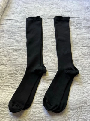 2st par nya svarta stödstrumpor knästrumpor i bomull - Säljer två par klassiska svarta stödstrumpor, knästrumpor i mjukt och stretchigt bomullsmaterial. Strumporna är ribbade och har en enkel, stilren design som passar perfekt till sneakers eller boots. Passar för dom som har stående jobb.