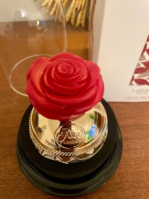 Lattafa Lahdath parfym med roslock - 80 ml flaska EDP Lahdath otroligt vacker presentation med rosenkorken.   Toppnoterna är Ros och Citron;  hjärtnoterna är Ros och Kola;  basnoterna är Vanilj, Musk och Cederträ.  Skickas väl inpackad i originalförpackningen.