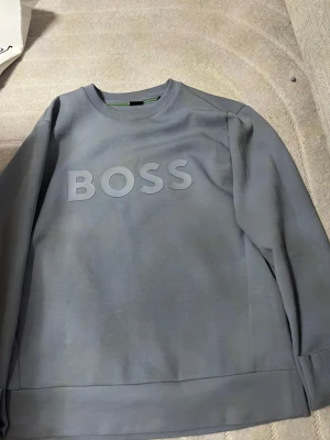 Blå sweatshirt från BOSS - Säljer min boss tröja eftersom behöver pengarna just nu köpte den för 1499kr, kvitto finns det är bara o be om den om det behövs.