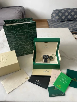 Role Yacht-Master svart klocka - Säljer en stilren Role Yacht-Master med svart urtavla och svart gummiband. Klockan har silverfärgade detaljer och levereras i originalbox med certifikat och tillbehör. Perfekt för dig som gillar exklusiva accessoarer och klassisk design.