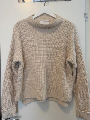 Beige stickad tröja från Selected Femme - Mysig beige stickad tröja från Selected Femme med avslappnad passform och rundad halsringning.  Jag skickar tyvärr inte fler bilder då plaggen ligger i flyttlåda.