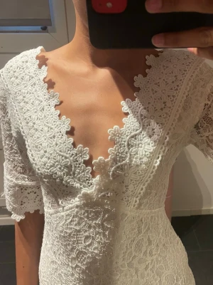 Studentklänning i v-ringning - Världens finaste klänning som är helt oanvänd. 💓💓 Den är super fin med unika blom mönster. Klänningen har trekvartsärm och är figurnära med vackert blommigt spetsmönster över hela plagget. Perfekt nu inför sommaren. 