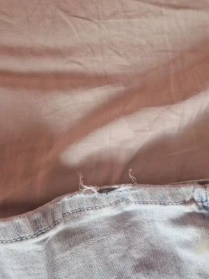 Ljusa bootcut-jeans med rosa detaljer - Superfina ljusa jeans i mycket bra skick. Utsvängda ben och söta rosa detaljer på bakfickorna.