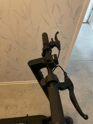 Iscooter i10 - Säljer en svart elscooter från iscooter med robusta handtag, tydlig handbroms och breda däck. Scootern har en stilren design i metall och plast, perfekt för smidig transport i stan. Laddningsbar och enkel att fälla ihop för förvaring.Laddare ingår 