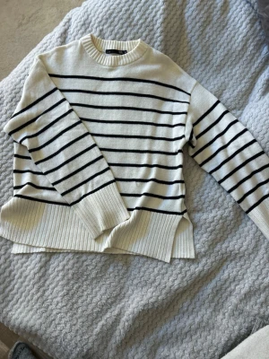 Vit stickad tröja med svarta ränder - Stickad tröja från Lager 157, är i storlek XS men passar för större storlekar med! 