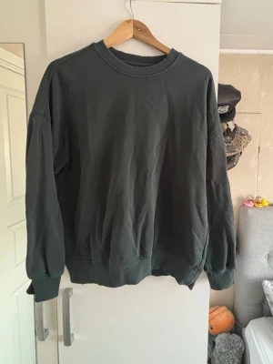 Mörkgrön oversized sweatshirt - En enkel mörkgrön oversized sweatshirt med rund halsringning och ribbade muddar vid ärmslut och nederkant. Perfekt för en avslappnad och stilren look. Tillverkad i mjukt bomullsmaterial.❤️‍🔥