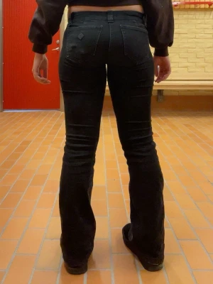 Svarta bootcut jeans från A brand - Säljer ett par svarta bootcut jeans med klassisk femficksdesign och låg midja från A brand. Jeansen har utsvängda ben och är tillverkade i ett stretchigt material som sitter snyggt. Perfekta för dig som gillar en tidlös och trendig look. Dom är igentligen kolsvarta men vet ej hur man tvättar svarta jeans…. Köpte nyligen för cirka 3 månader gått upp i vikt så dom passar inte mig nå mer