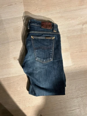 Blåa Nudie Skinny Lin Jeans Storlek W29 L34 - Fina Nudie Jeans i blå färg. Jeansen är i mycket bra skick och sparsamt använda.  Äkta som allt annat jag säljer! ✅  Storlek: W29 L34 Skick: Mycket Bra Skick Färg: Blå Märke: Nudie Modell: Jeans   Hör gärna av dig vid frågor så svarar jag så fort jag kan! 😁  